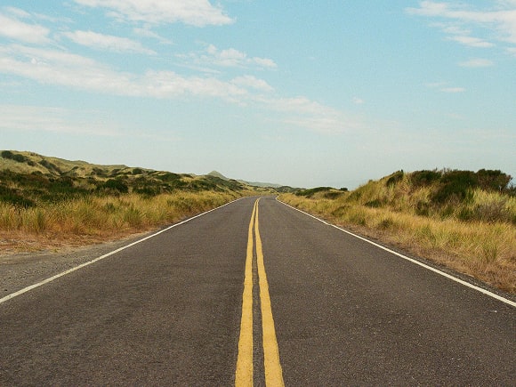 Empty road through a field